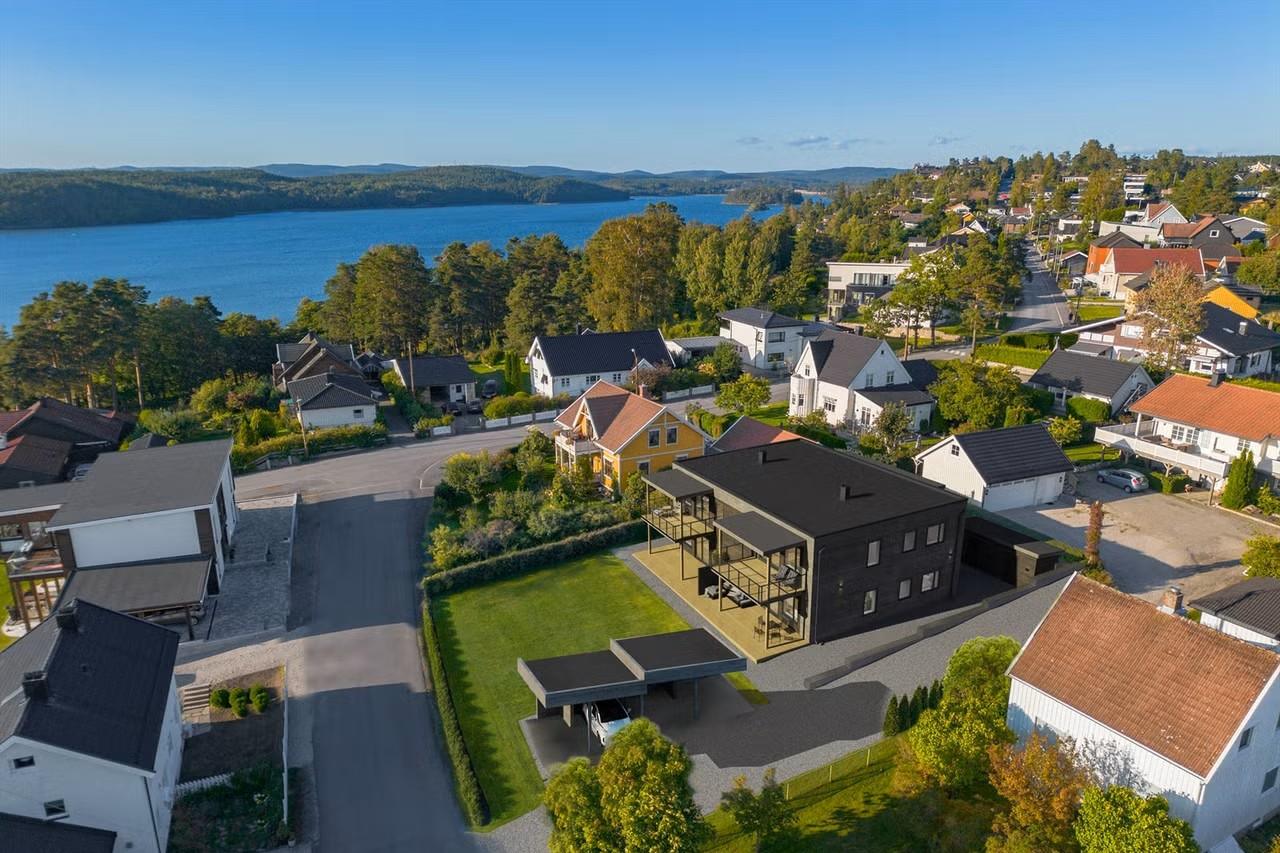 Ny bolig i mørkt tre sett ovenfra, med fjorden bak