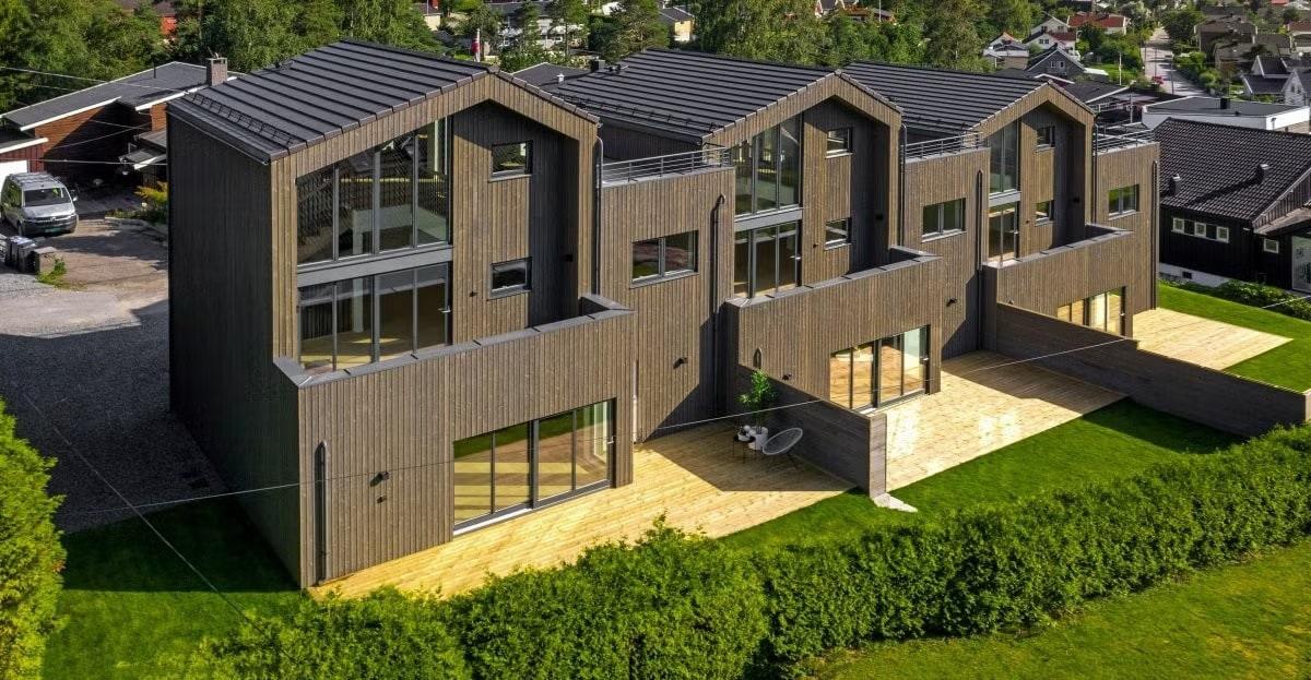 Rekke med nye boliger i mørkt tre med saltak, Skytterveien 3